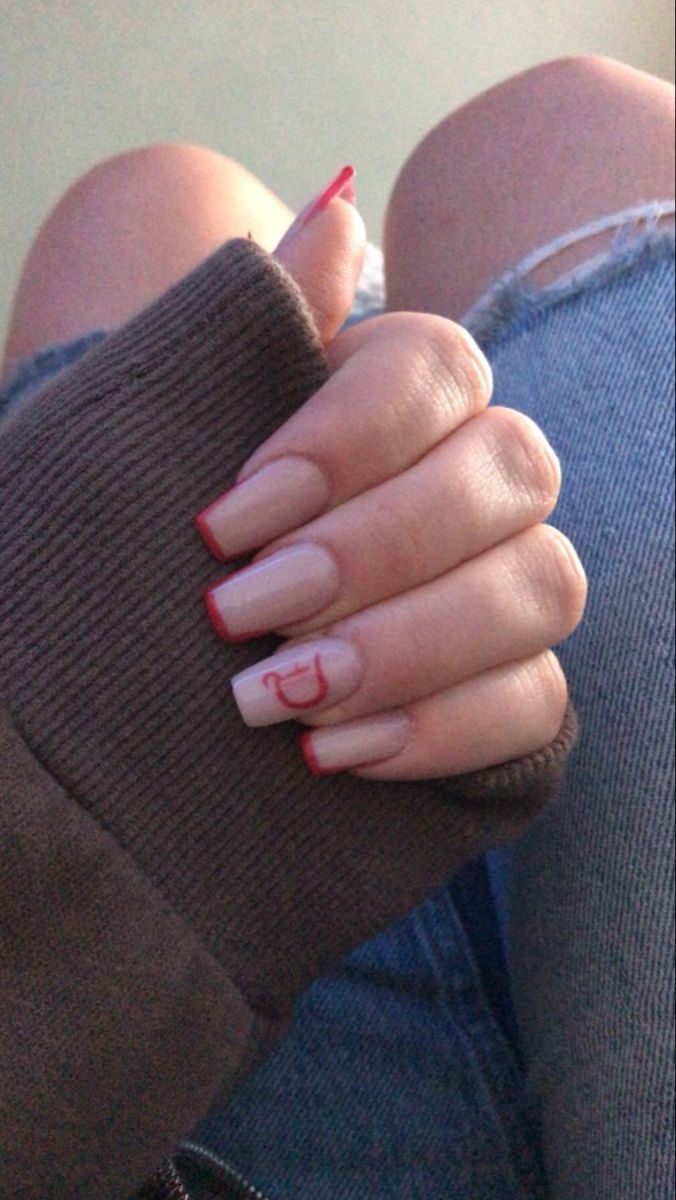 Chic Nail Design: Natural Base with Striking Red Tips and Whimsical Accent.