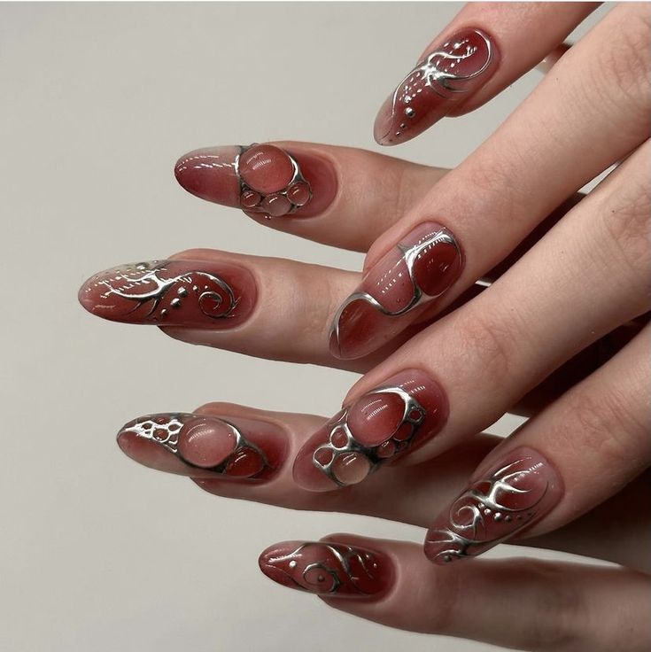 Elegant Nail Design with Soft Hues, Metallic Patterns, and Eye-Catching Embellishments.