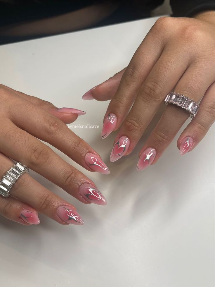 Chic Almond-Shaped Nails with Soft Pink Gradient and Abstract Designs.