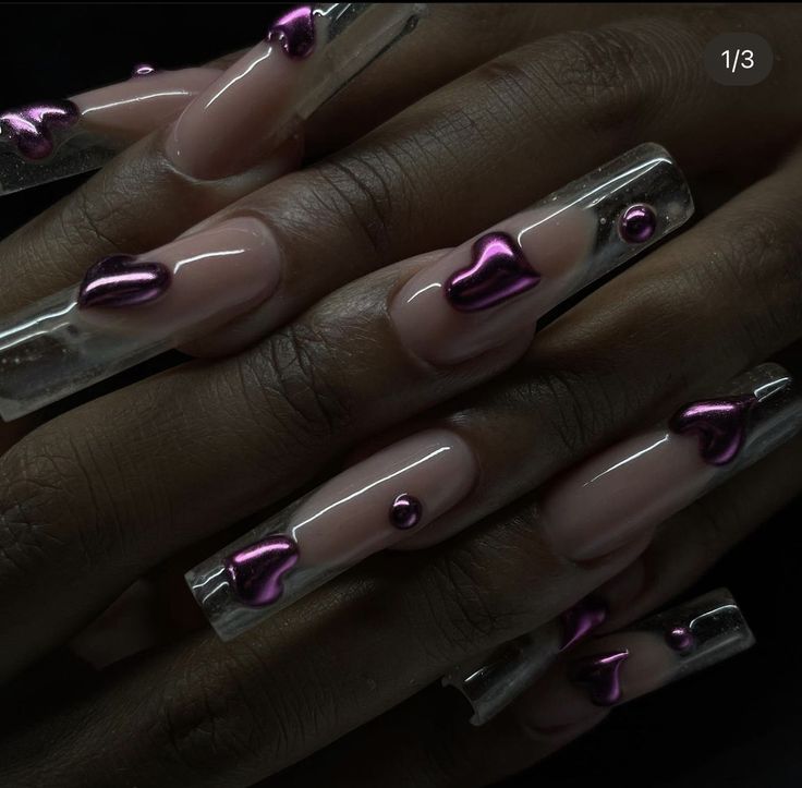 Chic Long Nails: Clear and Nude Polish with Purple Metallic Heart Designs for an Elegant Playful Look.