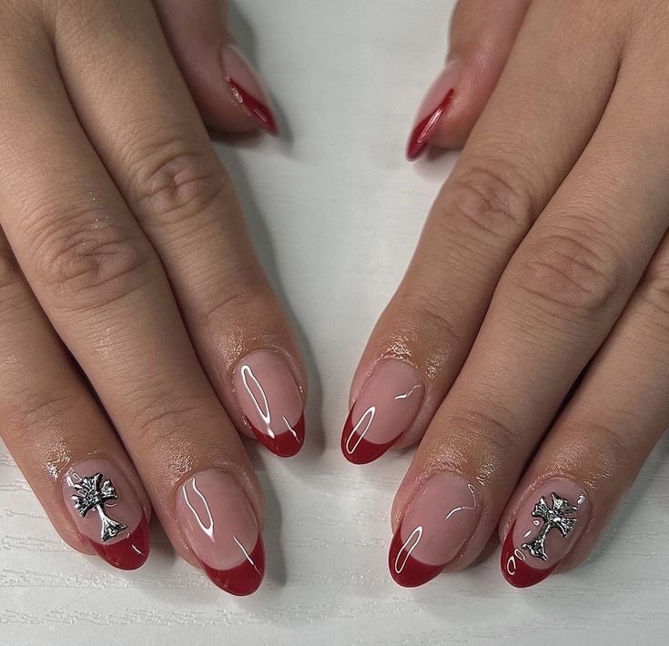 Sophisticated Red French Tips with Glossy Nude Base and Intricate Silver Charms.