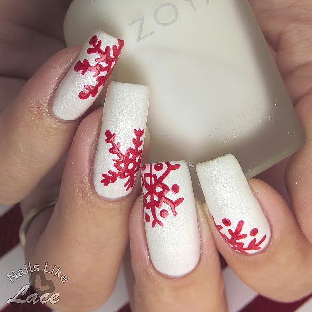 Elegant Winter-Themed Nail Design with Matte White Base and Red Snowflake Patterns.