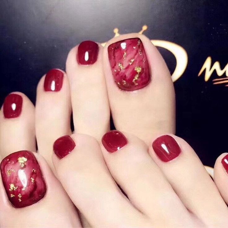 Luxurious Glossy Red Toenail Design with Gold Accent for Glamorous Pedicure.