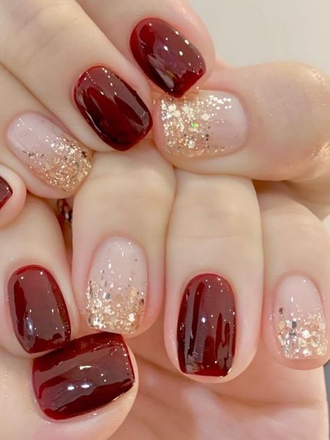 Luxurious Burgundy Nail Design with Sparkling Gold and Nude Accents.