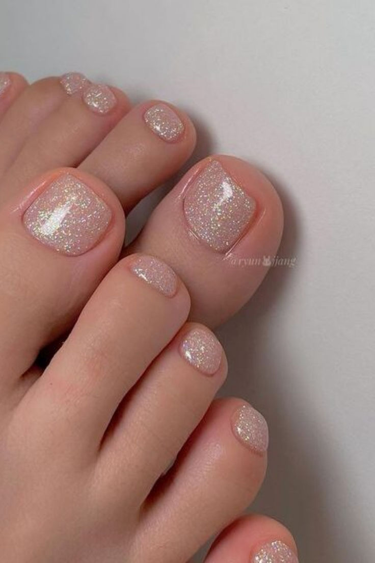 Elegant Sparkling Nail Design with Nude Base and Glitter Accents for a Polished Look