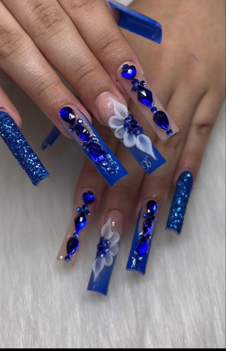 Elegant Striking Blue Nail Design with Glitter and Gems.