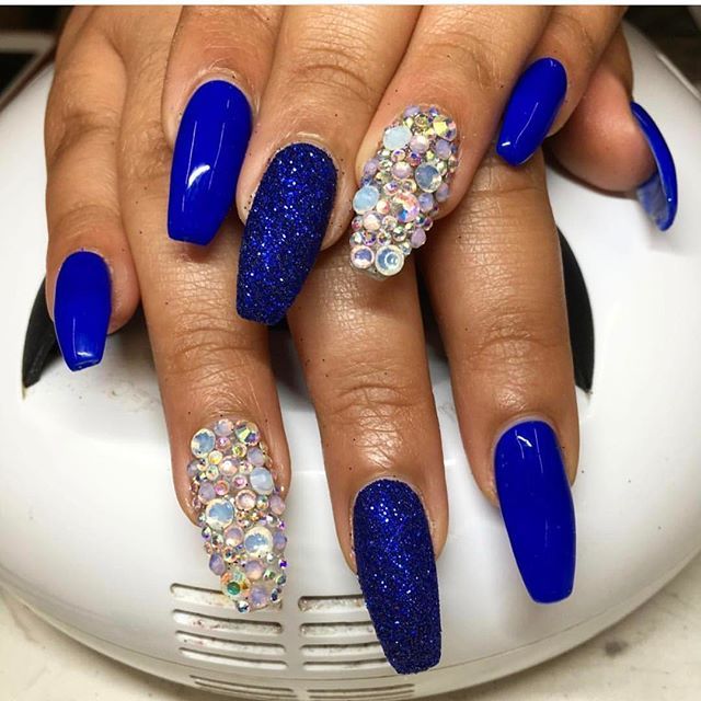 Glamorous Vibrant Blue Nail Design with Glossy, Textured Finishes and Rhinestone Accents.