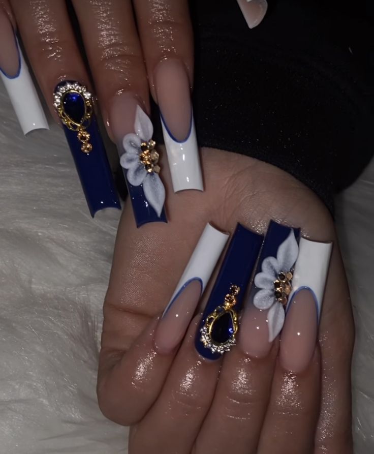 Elegant Navy Blue and White Nail Design with Floral Accents and Gold Embellishments.