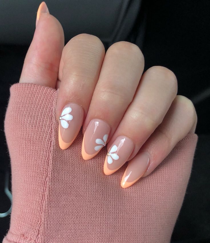 Charming Nude and Peach Nail Design with Delicate Flower Accents.