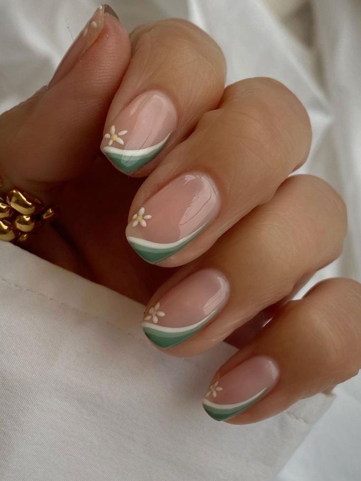 Elegant Spring-Inspired Nail Design with Floral Accents and Green Tips on Soft Pink Base.