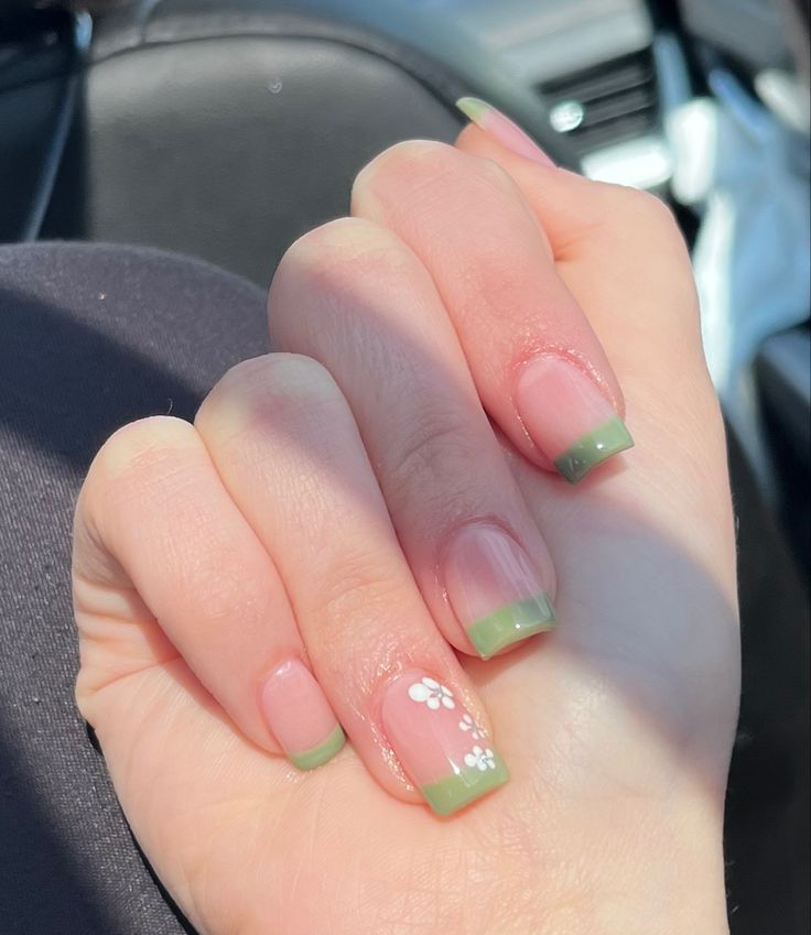 Charming Spring-Inspired Nail Design: Soft Pink Base with Green Tips and Floral Accents.