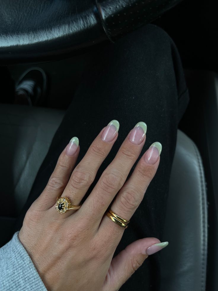 Chic French Tip Nail Design with Delicate Green Tips and Gold Ring Accents