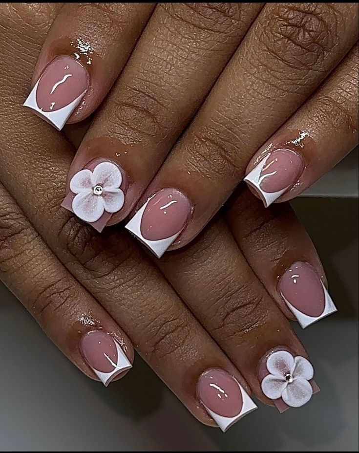 Elegant Soft Pink Nail Design with White Triangular Tips and Floral Accents