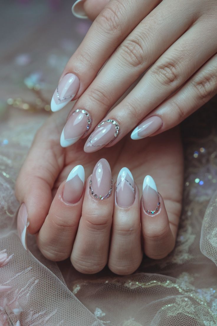 Chic French Manicure with Nude and White Tips, Accented by Rhinestones and Geometric Designs.