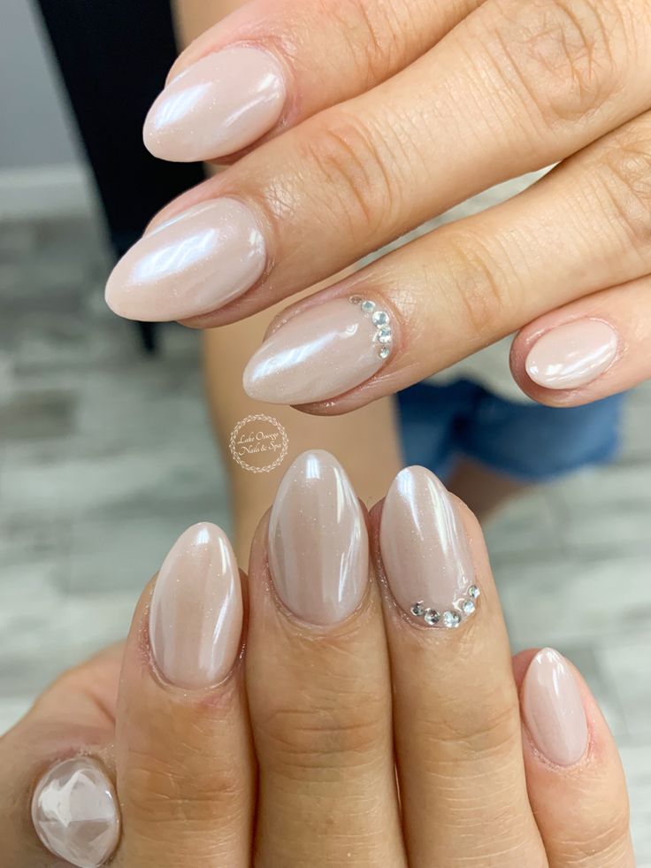 Refined Nude Nail Design with Glossy Finish and Subtle Rhinestone Accents.