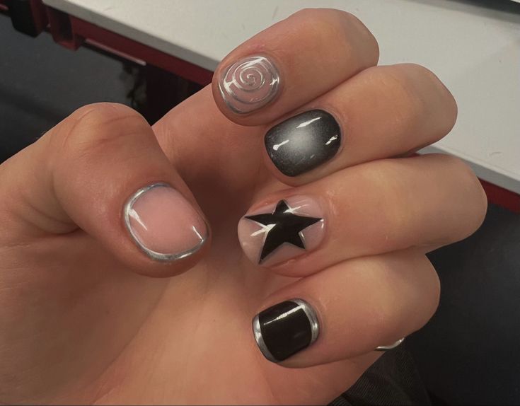 Modern Nail Design: Glossy Black, Soft Nude, and Metallic Silver with Hand-Painted Rose and Bold Star Motif.