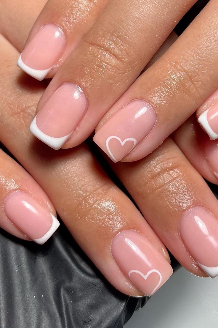 Chic Elegant Nail Design: Soft Pink Base, Classic White Tips, and Delicate Heart Motifs.