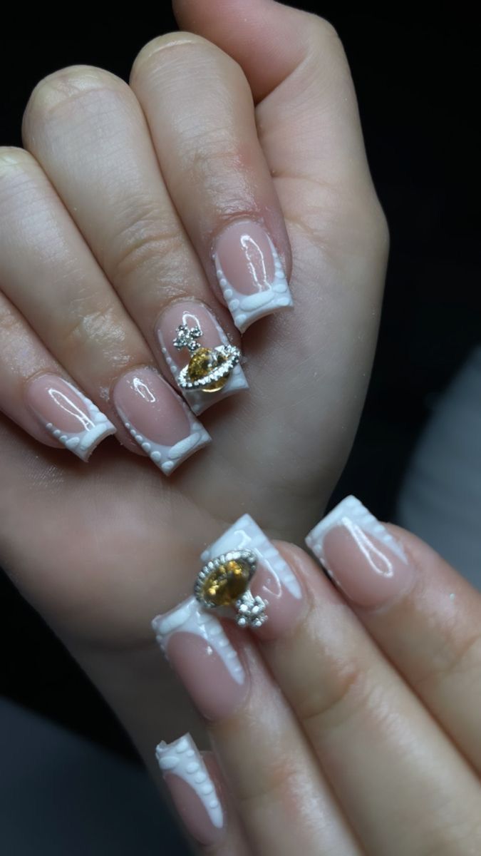 Elegant French Tip Nail Design Enhanced with Gold and Crystal Accents for a Glamorous Look.