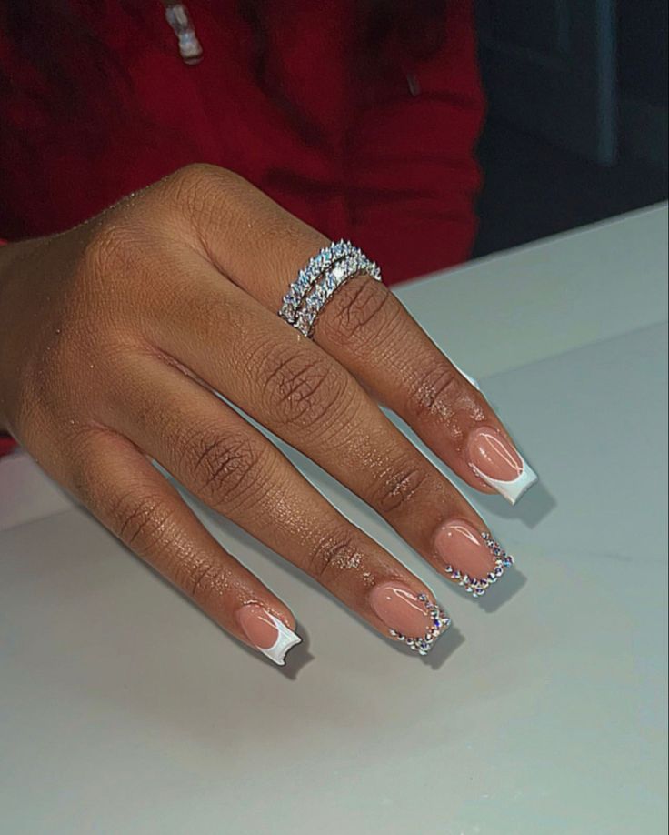 Sophisticated Nude French Tip Nails with Rhinestone Accents and Sparkling Stackable Ring.