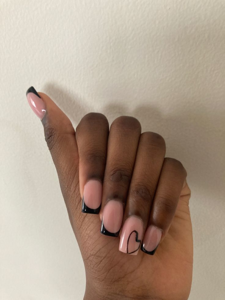 Chic Nude Nails with Bold Black French Tips and Heart Accents.