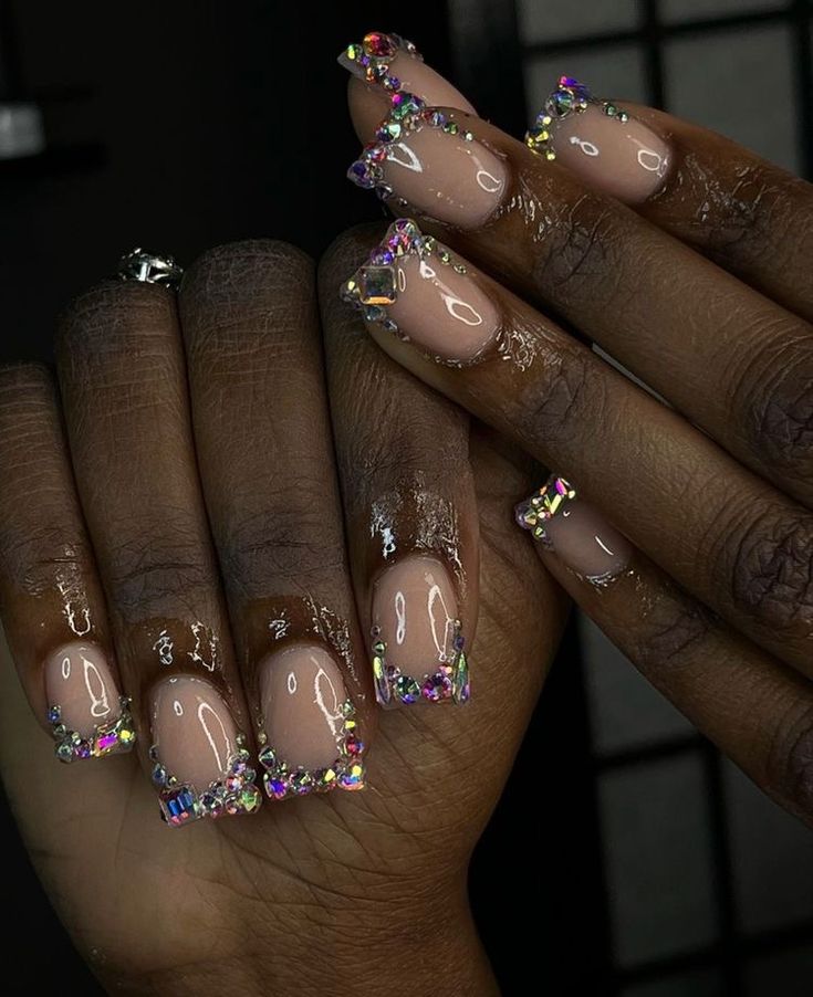 Elegant Nude Nail Design Embellished with Colorful Rhinestones for a Luxurious Touch.