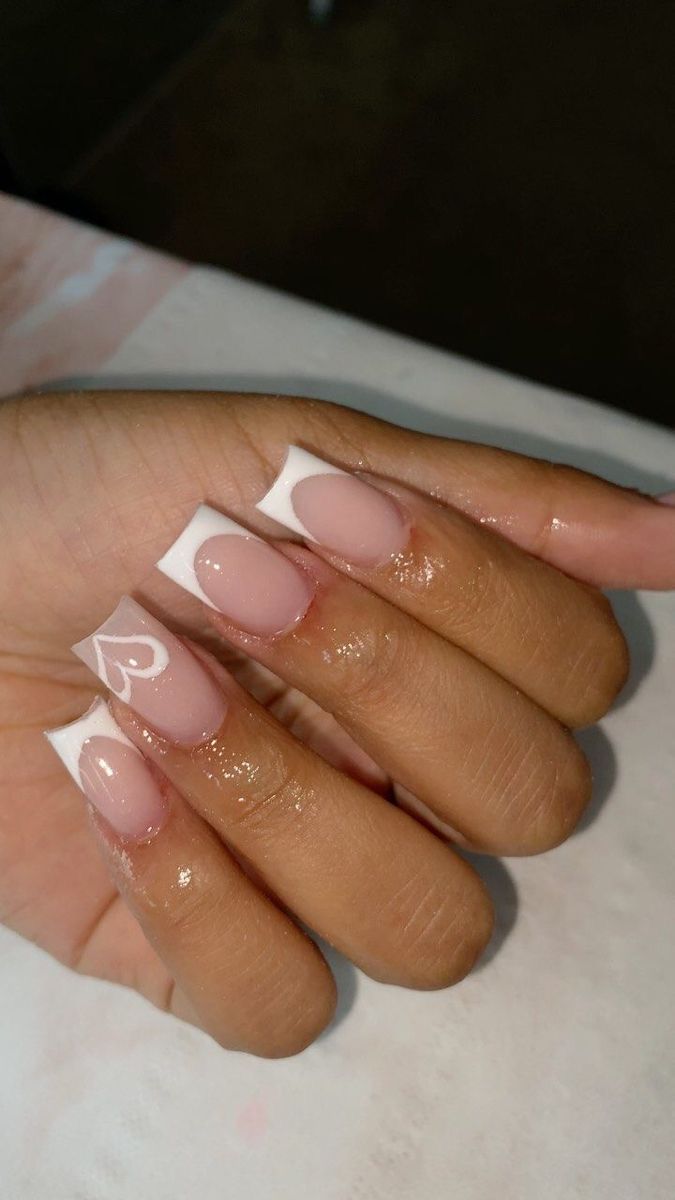 Chic Nude and White French Tips with Playful Heart Accents for Elegant Manicure.