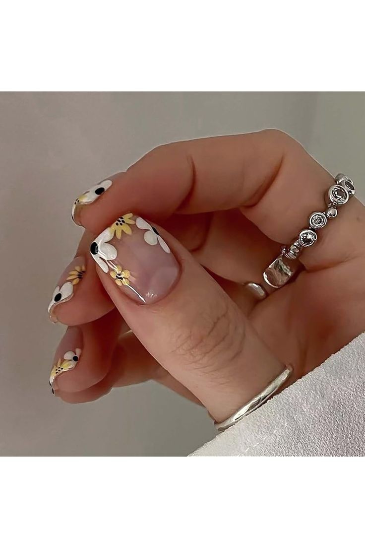 Whimsical Floral Nail Design with Delicate Daisies for a Fresh Spring/Summer Aesthetic.