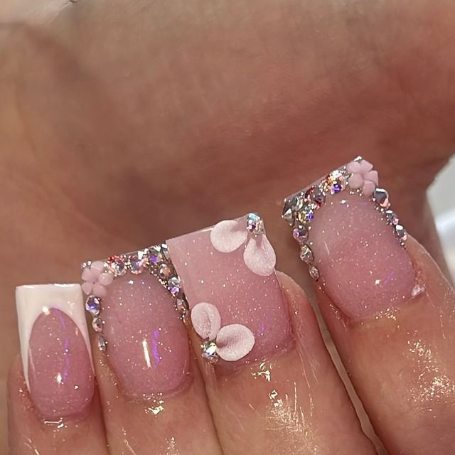 Sophisticated Pink Nail Design with Glossy and Matte Finishes, Floral Accents, and Sparkling Rhinestones.