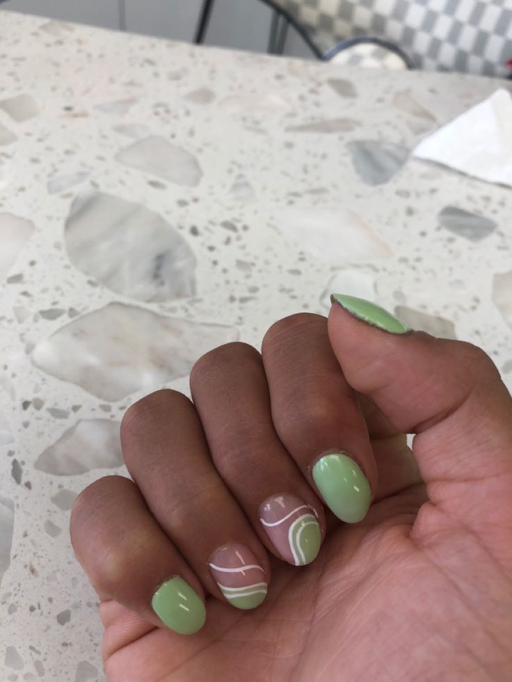 Playful Pastel Green Nail Design with Elegant Abstract Swirls for Spring Aesthetic.