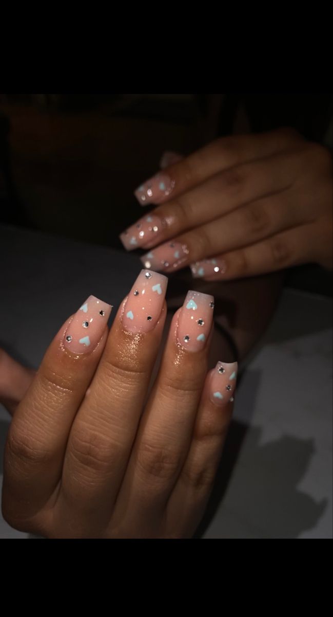 Elegant Chic Nail Design: Soft Pink Base with Delicate Blue Hearts and Sparkly Accents.