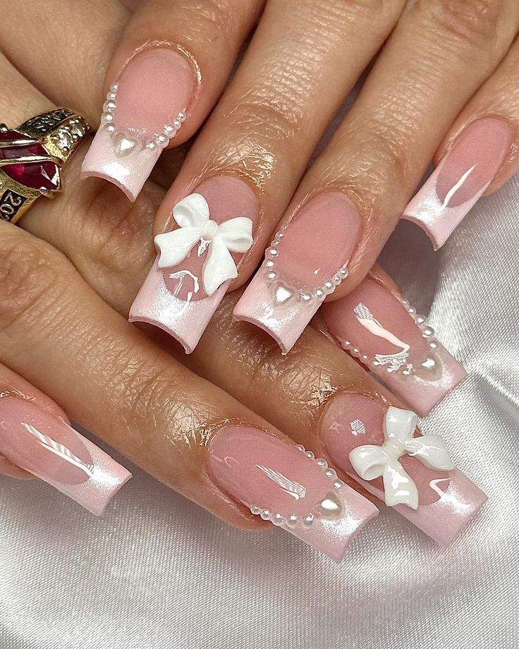 Sophisticated Light Pink Acrylic Nail Design with Glossy White Tips and Playful Embellishments.