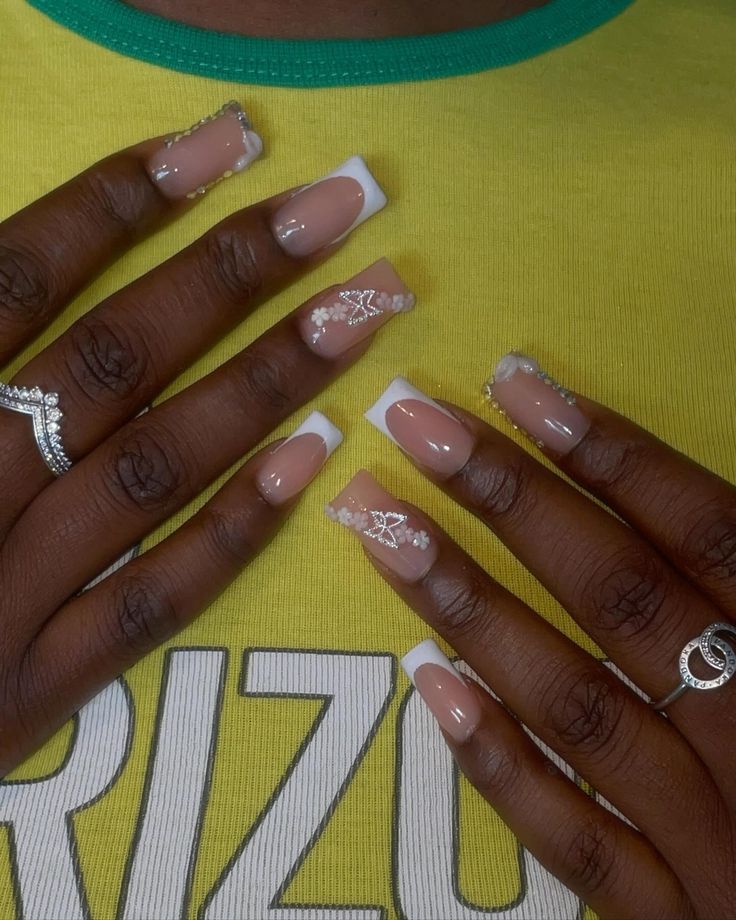 Sophisticated French Manicure with Nude Base, White Tips, and Glamorous Embellishments.