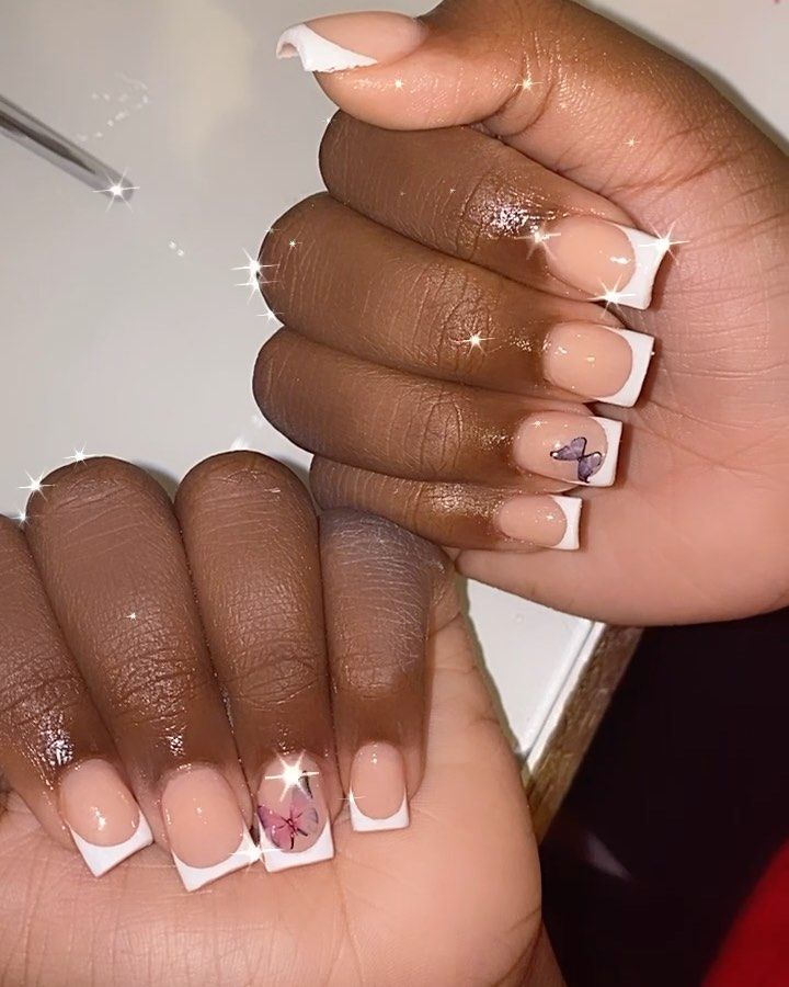 Chic French Manicure with Elegant Floral and Butterfly Artistry.