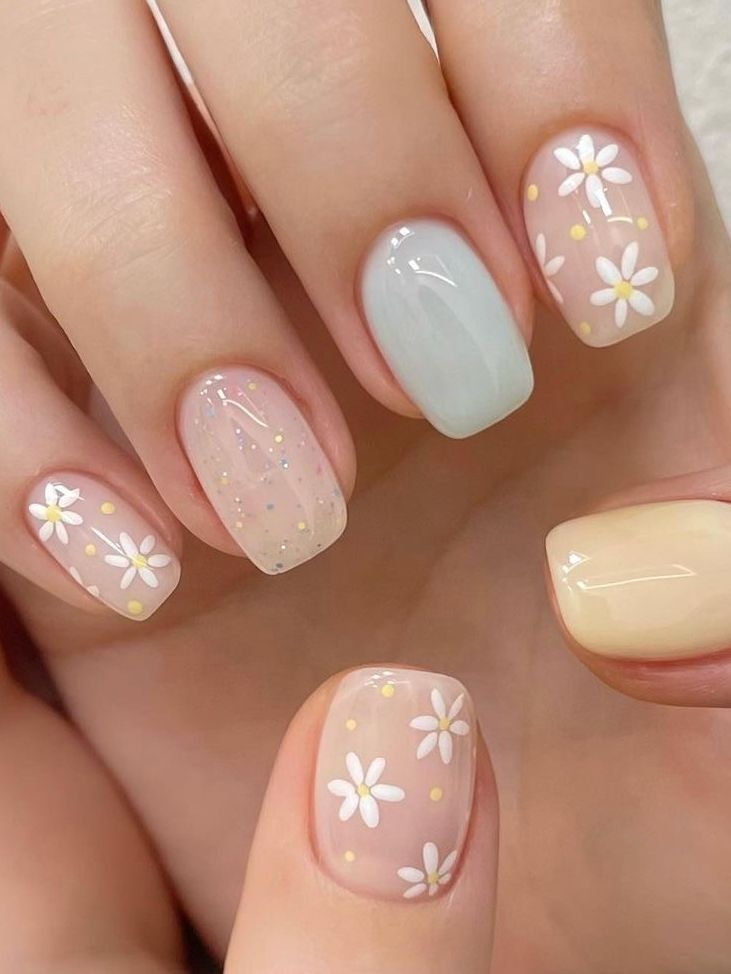 Delicate Floral Nail Design with Pastel Daisies and Sparkling Accents.