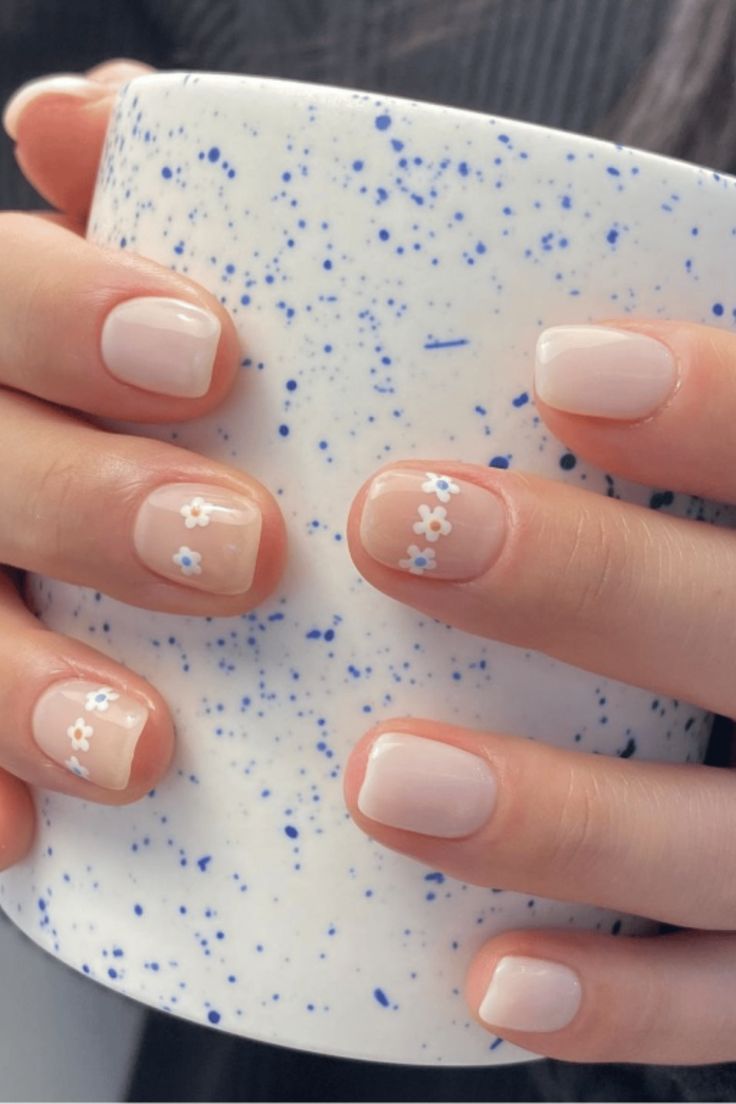 Charming Delicate Floral Nail Design: Soft Nude Base with Blue and White Accents for a Fresh Spring/Summer Look.