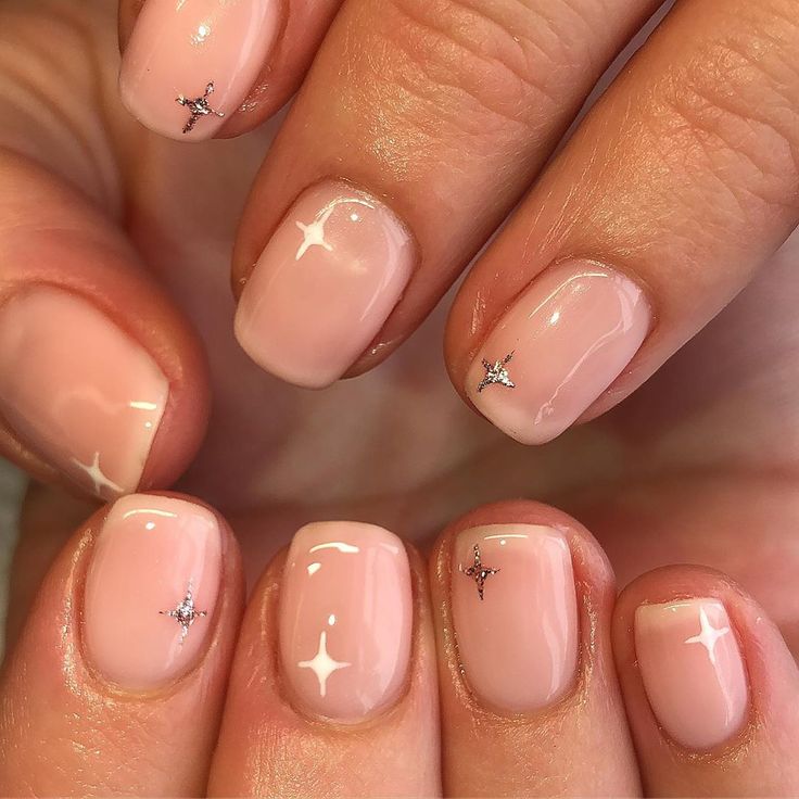 Charming Shiny Nude Nails with Delicate Silver Star Accents for an Elegant Touch.