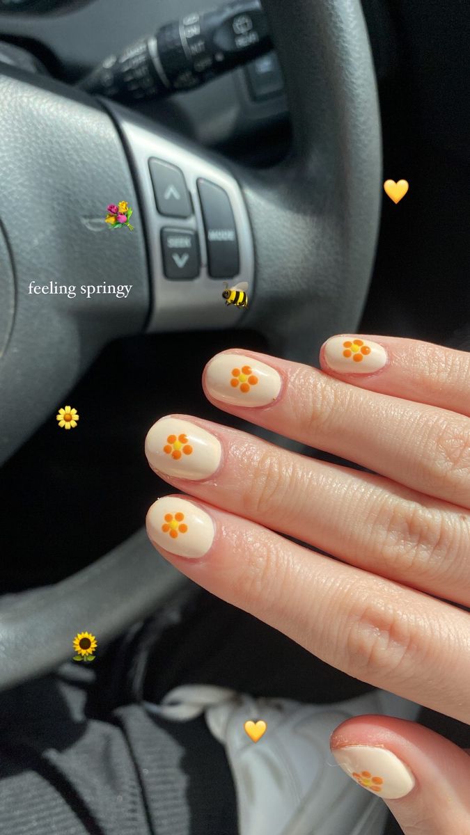 Playful Spring-Inspired Nail Design with Beige Base and Orange Floral Accents.