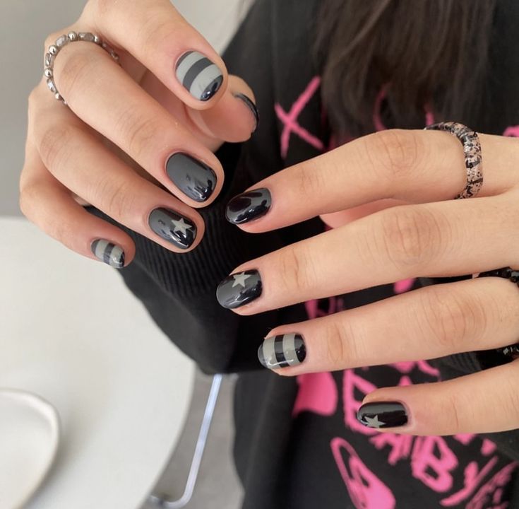 Chic Matte Black and Gray Nail Design with Geometric Stripes and Star Accents for a Bold Yet Sophisticated Look.