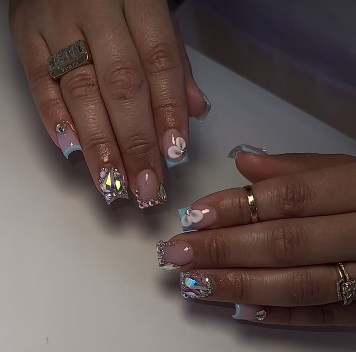 Chic Pastel Nail Design with Floral Accents and Sparkling Embellishments.