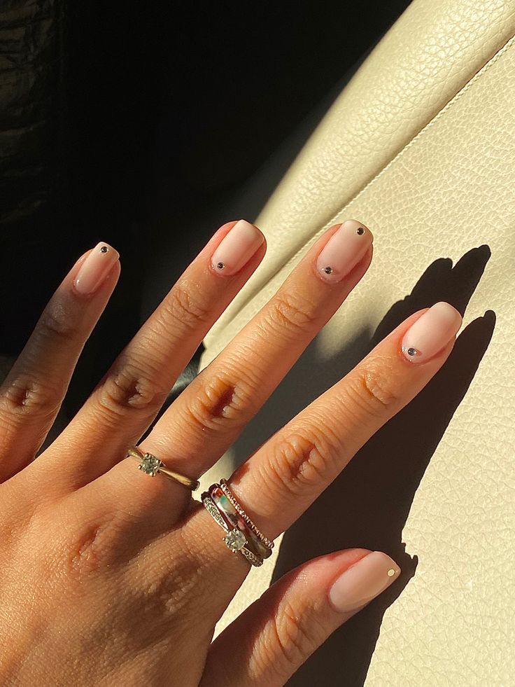 Chic Pink Pastel Nails with Minimalistic Black Dots for Elegant Simplicity.