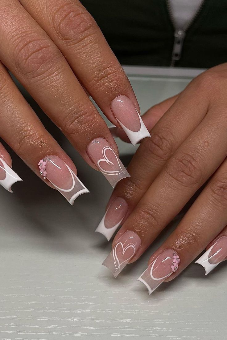 Chic Pink and White French Tip Nails with Heart Patterns and Pearl Embellishments.