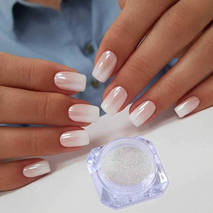 Elegant Ombre Nail Art: A Smooth White to Pink Gradient with Shiny Finish and Glitter Accents.