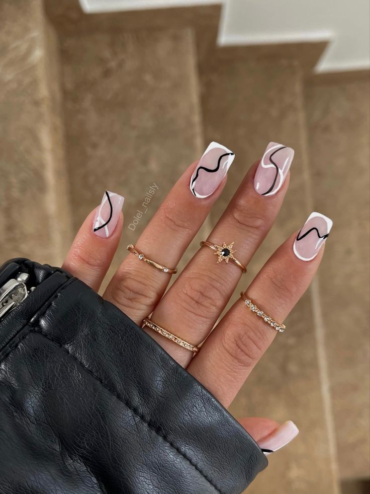 Chic Elegant Nail Design: Nude Base with Flowing Black Lines and Delicate Accent Rings.