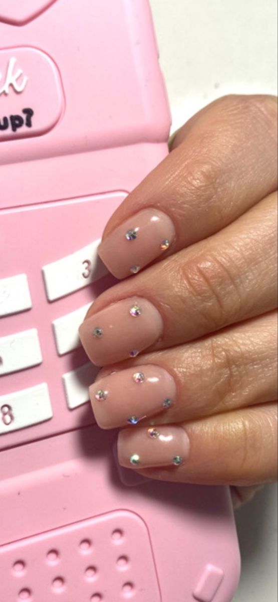 Elegant Soft Nude Nails with Sparkling Rhinestones: A Chic and Playful Design.