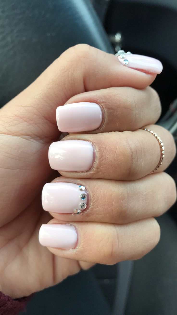 Chic Minimalist Nail Design: Soft Pink Polish Accentuated with Shimmering Rhinestones for Versatile Elegance.