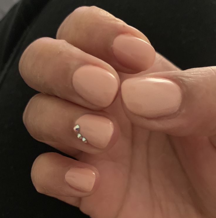 Elegant Nude Nail Design with Glamorous Gemstone Accents