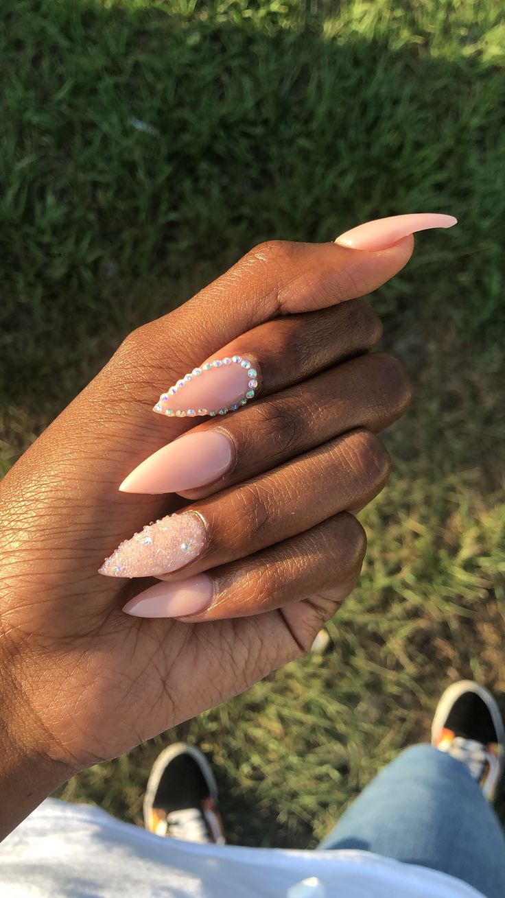 Chic Nail Design: Soft Nude Base with Pearl Accents and Glitter Finish.