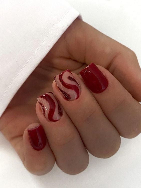 Sophisticated Elegant Nail Design: Rich Red Base with Playful Waves and Subtle Glitter