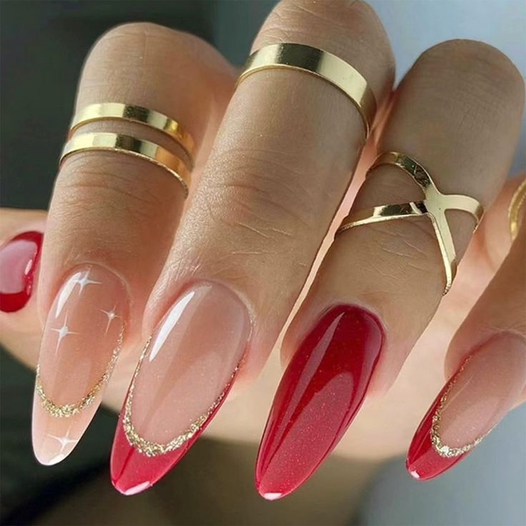 Glamorous Nail Design: Deep Red and Translucent Nude with Gold Accents and Sparkling Elements.