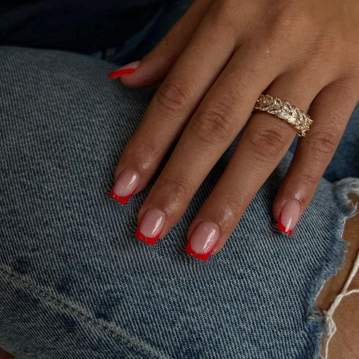 Chic Trendy French Tip Nail Design with Vibrant Red Accents and Elegant Gold Ring.